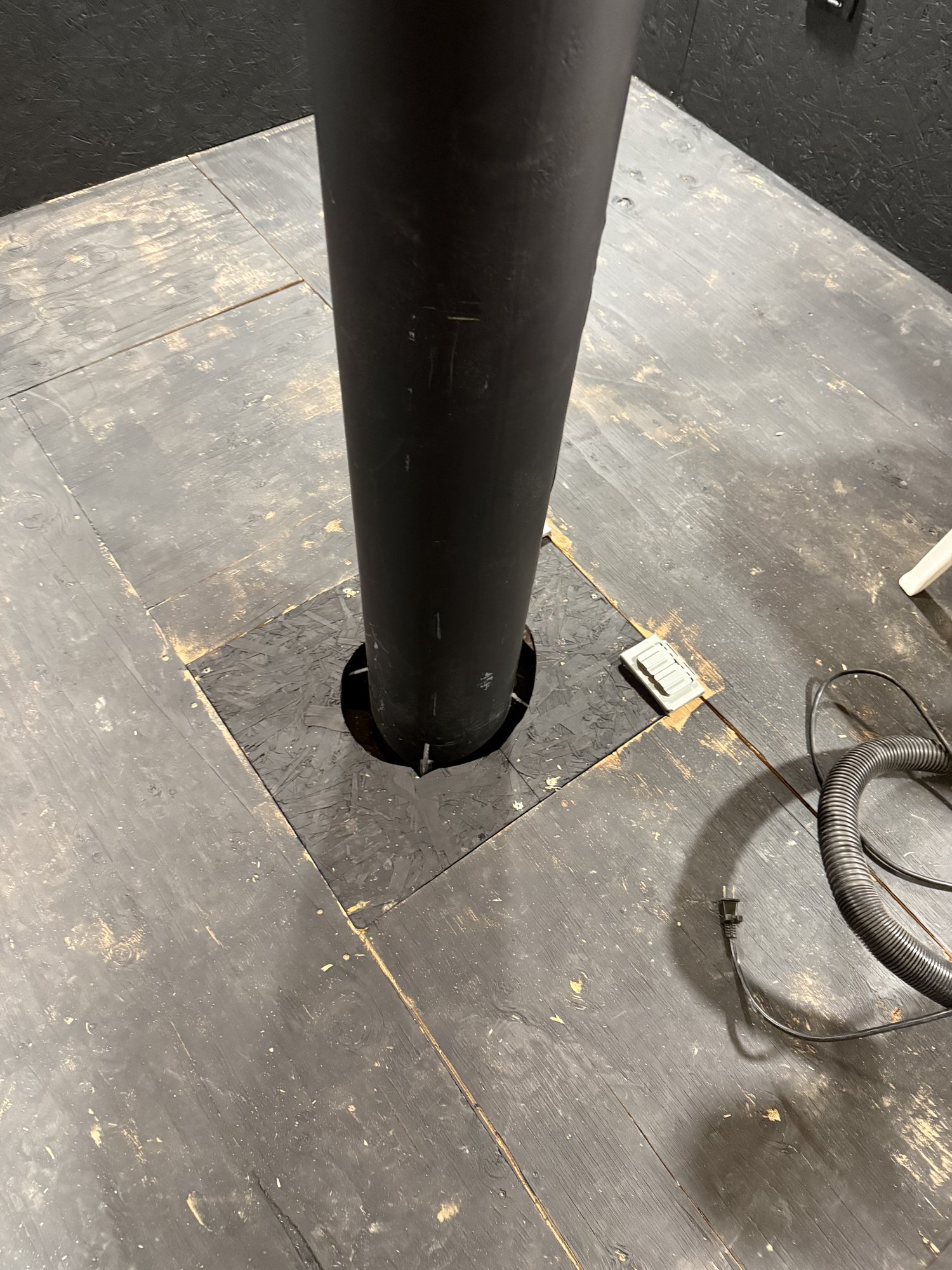 The steel pier passing through a cutout in the finished observatory floor, with a visible gap separating it from the surrounding structure